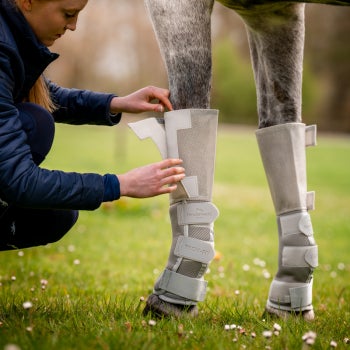 Girl putting on the Rambo® Tech-Fit Fly Boot on her horse