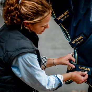 Fitting a blanket around a horses neck